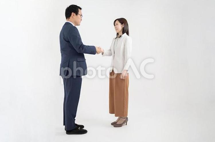 握手をする笑顔の男女のビジネスマンｰ全身引き白背景 握手,全身,女性の写真素材