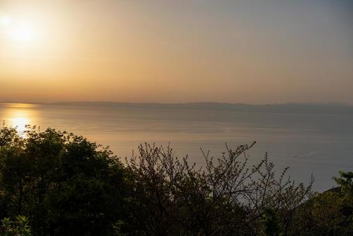 夕焼けの海と遠くの山並み 自然,風景,夕焼けの写真素材