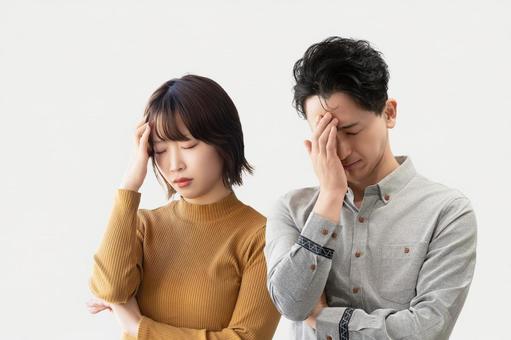 頭を押さえて悩む男女2人のビジネスマン 頭を押さえて悩む男女2人のビジネスマン 男性,女性,男女の写真素材