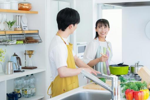 キッチンで料理を作る若い夫婦 夫婦,料理,キッチンの写真素材
