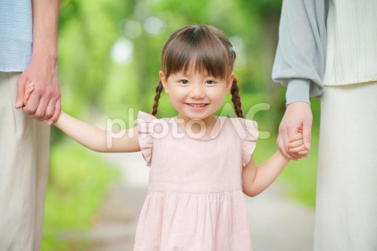 手を繋がれた笑顔の女の子 女の子,笑顔,手を繋ぐの写真素材