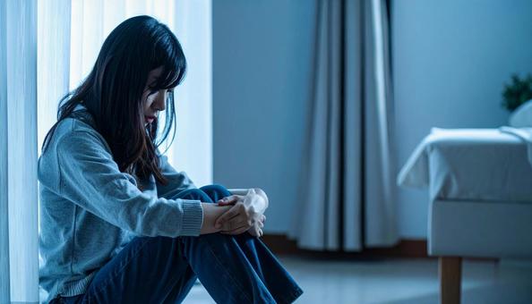 部屋で落ち込んで座る日本人女性の横顔 部屋で落ち込んで座る日本人女性の横顔の写真
