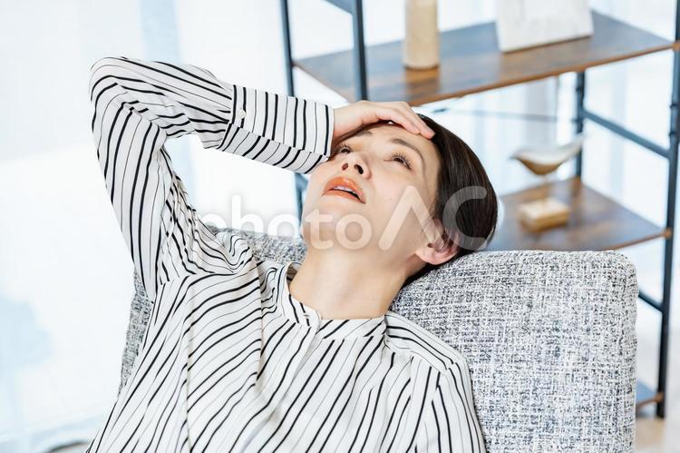 ソファに項垂れる女性 女性,ミドル,心配の写真素材