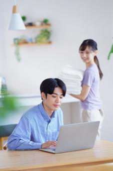 パソコン中の男性を見る笑顔の女性 パソコン中の男性を見る笑顔の女性の写真