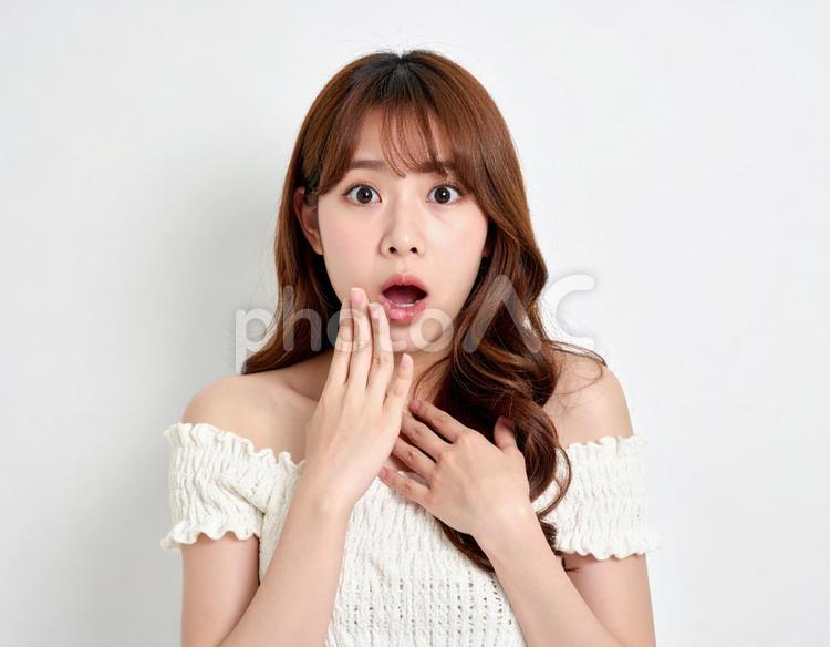 びっくりして目を見開く女性　白背景 びっくり,驚き,目を見開いたの写真素材