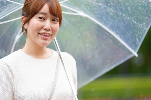傘を差し笑う女性の写真