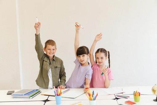 ペンを持って手を挙げる生徒たち 男の子,女の子,子どもの写真素材