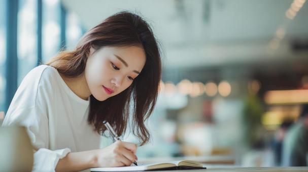 カフェで勉強している女性 カフェで勉強している女性の写真