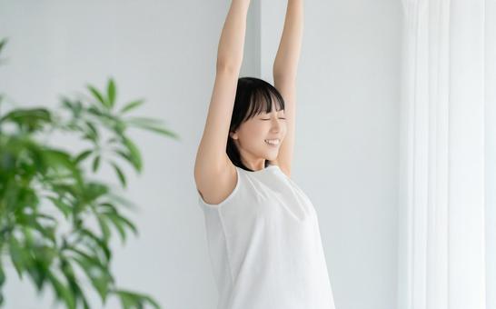 窓際でストレッチをする若い女性 窓際でストレッチをする若い女性 女性,美容,健康の写真素材