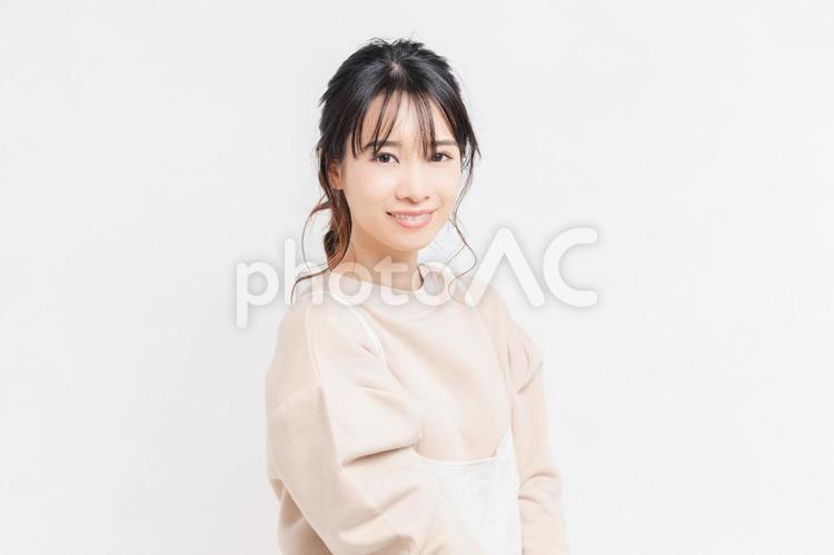 白い背景の前に立ってポーズをとる若い女性 女性,白背景,立つの写真素材