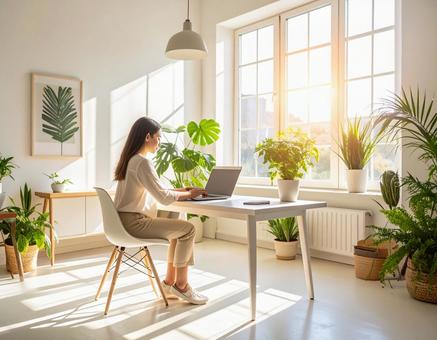 部屋でパソコンで仕事をする女性の写真