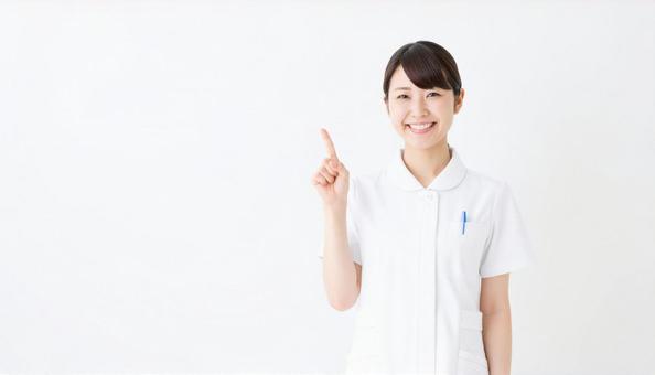 笑顔で指差ししている日本人女性看護師 笑顔で指差ししている日本人女性看護師の写真