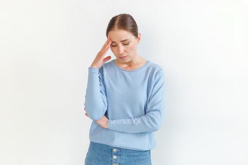 頭痛で頭を押さえる女性 生理,月経,女性の写真素材