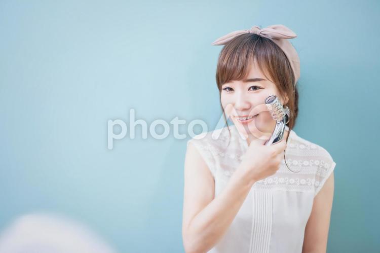 美顔ローラーを使う女性 小顔,美顔ローラー,むくみの写真素材