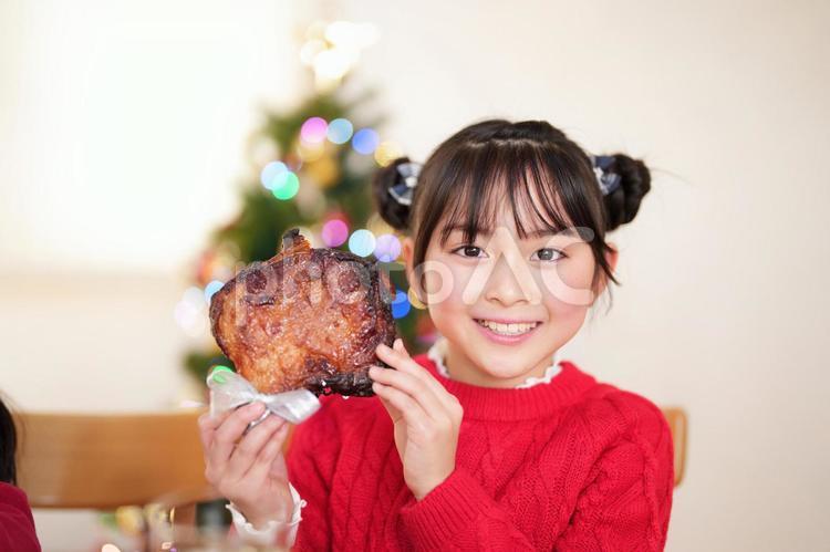 両手でチキンを持つ笑顔の女の子 女の子,チキン,持つの写真素材