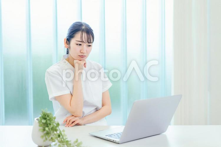 パソコンを使う白衣姿の女性（困る） 看護師,ナース,医療事務の写真素材