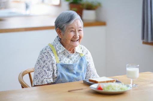 朝食を前に笑う高齢女性 女性,食事,朝食の写真素材