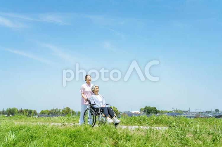 車椅子を押す介護士 介護士,笑顔,車椅子の写真素材