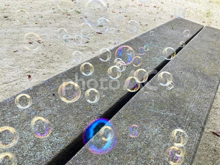 ベンチとたくさんのシャボン玉 シャボン玉,玉ボケ,虹色の写真素材