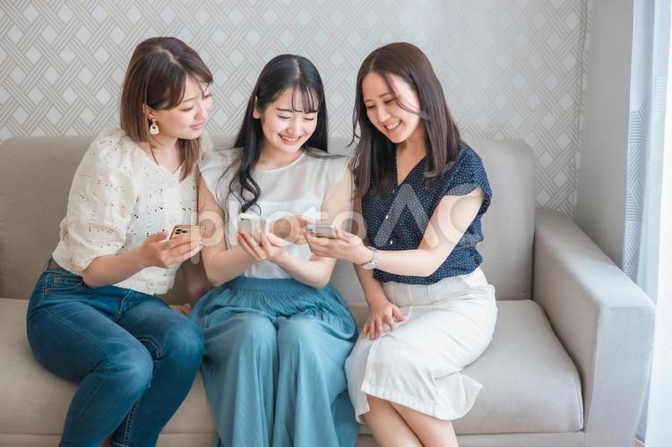 スマホを使う女性たち（爆笑） スマートフォン,スマホ,女子会の写真素材