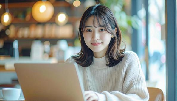 カフェでノートパソコンを使う日本人女性 カフェでノートパソコンを使う日本人女性の写真