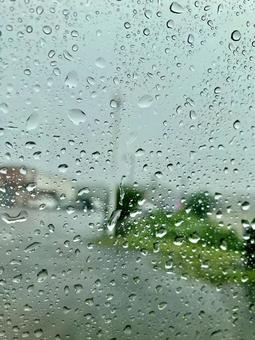 水滴のついた窓ガラス越しの街並み 水滴のついた窓ガラス越しの街並みの写真