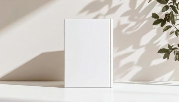 植物の影が落ちる、無地の本モックアップの写真
