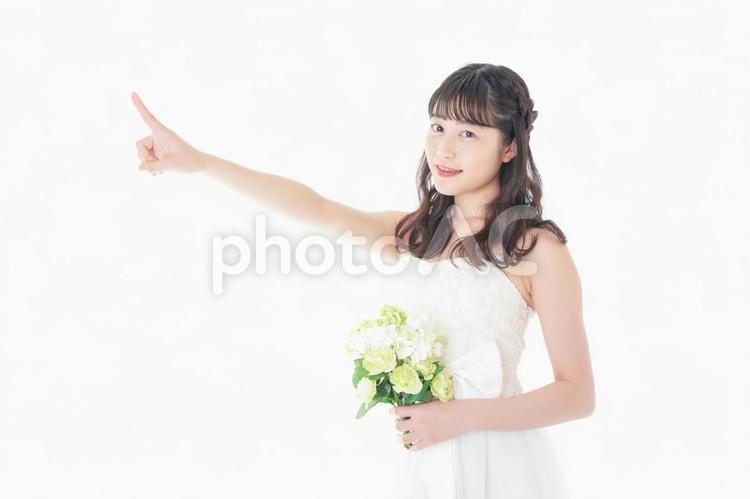 ブーケを持ち指差す花嫁の女性 コピースペース,衣装,中国人の写真素材
