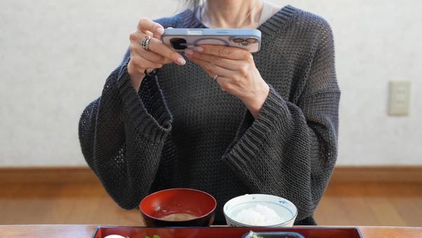 スマホで写真を撮る女性 スマホで写真を撮る女性 旅館,朝食,女性の写真素材