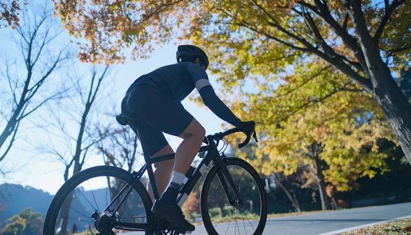 ロードバイクでサイクリングする男性 ロードバイクでサイクリングする男性の写真