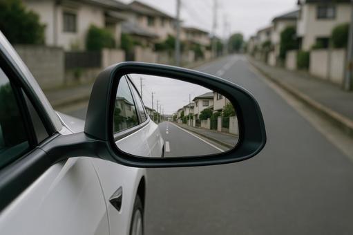 サイドミラーに映る街並みと車の後方風景 サイドミラーに映る街並みと車の後方風景の写真