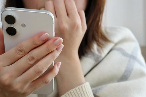 スマホを見て驚く女性 驚く,不安,動揺の写真素材