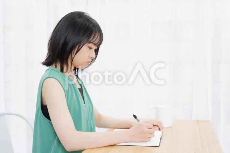 ノートに文字を書いている若い女性 ノート,女性,若いの写真素材