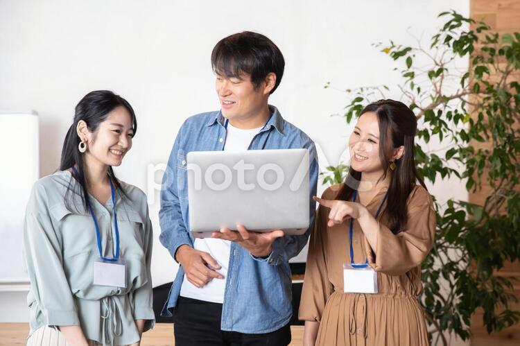 ノートパソコンをみる男女の会社員 ビジネス,企画,デザイナーの写真素材