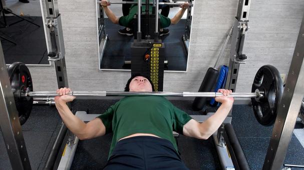 スポーツジムでベンチプレスをする若い男性 スポーツジムでベンチプレスをする若い男性 ベンチプレス,ジム,フィットネスの写真素材