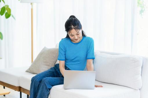 パソコンを操作する女性 女性,笑顔,ノートパソコンの写真素材