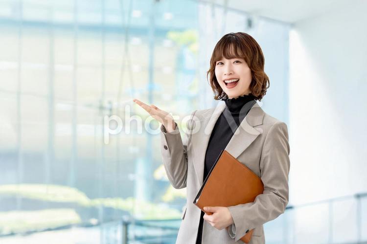 手で案内をする女性・ビジネスウーマン 女性,笑顔,案内の写真素材