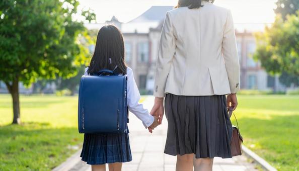 手をつないで歩く親子の後ろ姿 手をつないで歩く親子の後ろ姿の写真