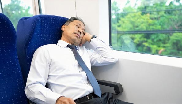 電車内で寝る中年男性 電車内で寝る中年男性の写真