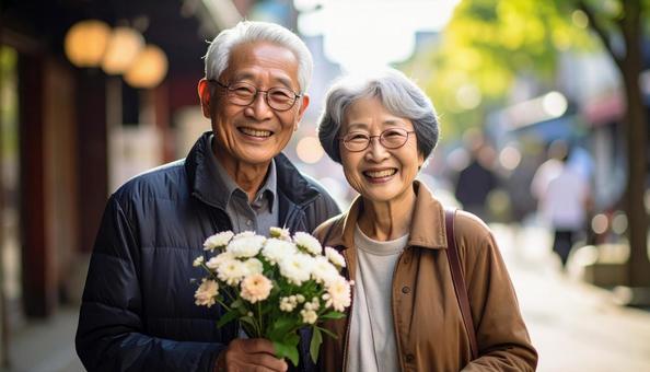 敬老の日 笑顔で花を抱えるシニア夫婦 敬老の日 笑顔で花を抱えるシニア夫婦の写真