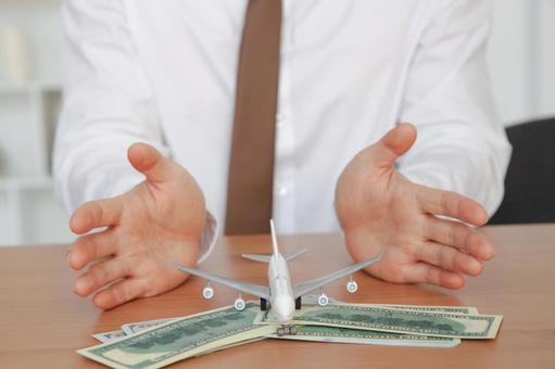 飛行機と紙幣を見せる手元 保険業,事務職,接客業の写真素材