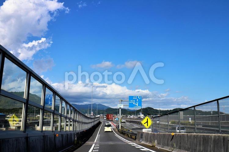 合流する車とフェンスが囲む道路 フェンス,道路,車の写真素材