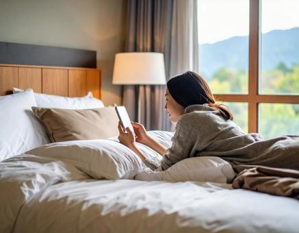 部屋のベッドでスマホを見る休日 部屋のベッドでスマホを見る休日の写真