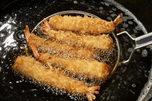 油で揚げているエビフライ(調理中) 油で揚げているエビフライ(調理中) 海老フライ,エビフライ,揚げるの写真素材