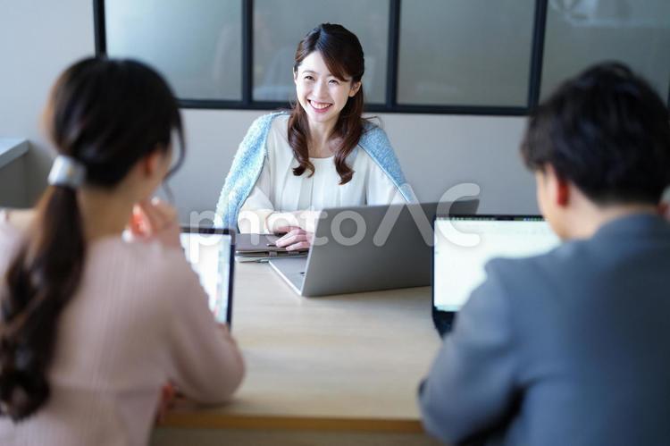 笑顔で話しを聞いているハーフアップの女性 女性,打合せ,笑顔の写真素材