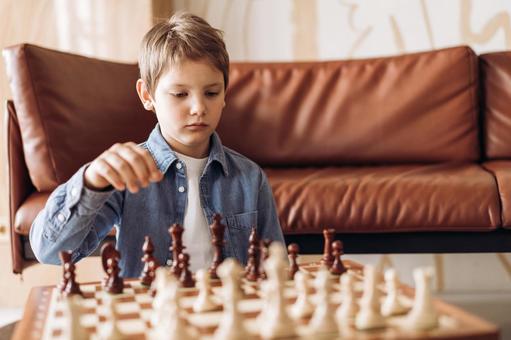 ソファテーブルでチェスをする男の子 ソファテーブルでチェスをする男の子 チェス,子ども,男の子の写真素材