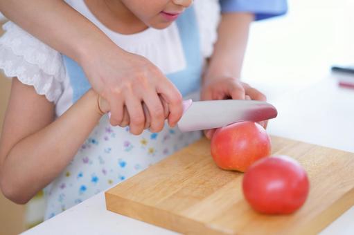 包丁を持つ娘の手を添える親の優しい手元 トマト,野菜,包丁の写真素材