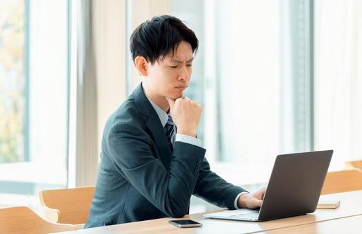 パソコンを使いながら悩む男性ビジネスマン パソコンを使いながら悩む男性ビジネスマン 男性,パソコン,悩むの写真素材