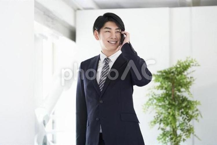 笑顔で通話する日本人男性ビジネスマン ビジネス,男性,ビジネスマンの写真素材