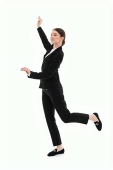 手や足をあげポーズするスーツの女性 手や足をあげポーズするスーツの女性の写真